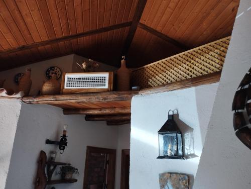 a room with a wooden ceiling with a shelf and a light at Posada del Moral in Benaoján