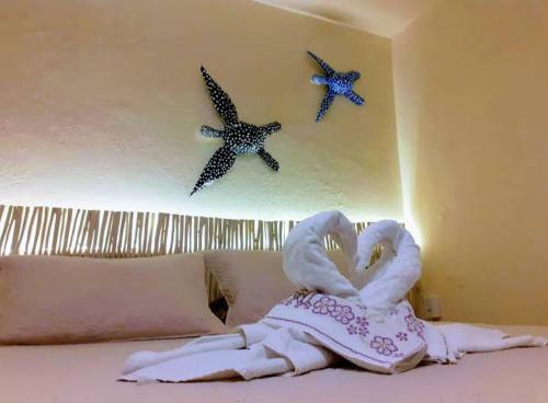 a bed with towels and two starfish on the wall at Happy Paradise in Natal