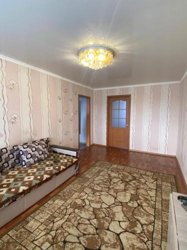 ein Wohnzimmer mit einem Sofa und einem Kronleuchter in der Unterkunft DEYA in Petropawlowsk
