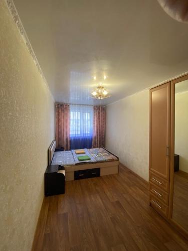 um quarto com uma cama num quarto com uma janela em DEYA em Petropavlovsk