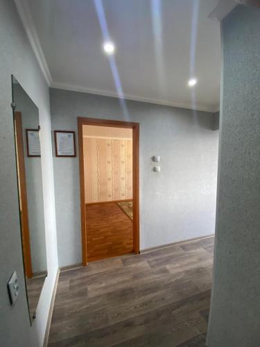 pasillo con puerta en una habitación con suelo de madera en DEYA en Petropavlovsk