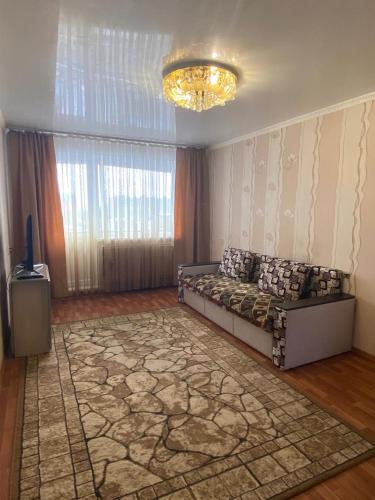 uma sala de estar com uma cama e um tapete em DEYA em Petropavlovsk