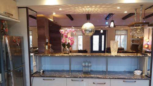 a kitchen with a counter with flowers and a refrigerator at APARTMENT B O R A in Tskaltubo