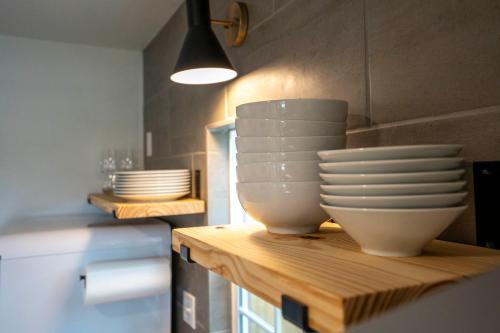 a group of bowls and plates on a counter in a kitchen at NEW! The Yellow Door- Downtown Wimberley w/ River Access in Wimberley