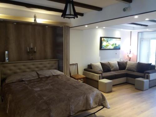 a bedroom with a bed and a couch at APARTMENT B O R A in Tskaltubo
