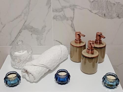 a bathroom with three bottles of soap and a towel at J&Z apartmán in Olomouc
