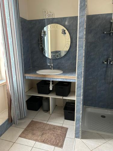 a bathroom with a sink and a mirror at Maison mitoyenne dans quartier calme in Saleich