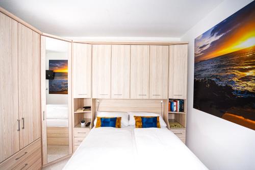 1 dormitorio con 1 cama blanca grande y 2 almohadas azules en Wiet Kieker - mit bestem Meerblick, en Sierksdorf