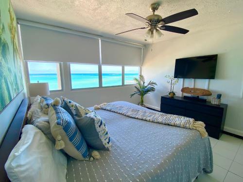 a bedroom with a bed and a ceiling fan at Marbella del Caribe Isla Verde Beachfront in San Juan