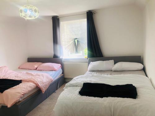two beds sitting next to each other in a bedroom at Charming Town centre 3 double beds home free parking in Tonbridge