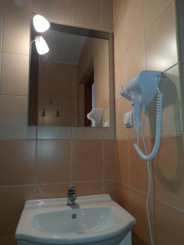 uma casa de banho com um lavatório e um telefone na parede em Willa Lenka em Rewal