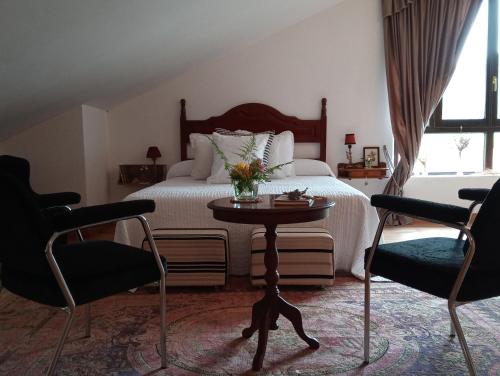 1 dormitorio con 1 cama con mesa y 2 sillas en Palacio de Arredondo en Gama
