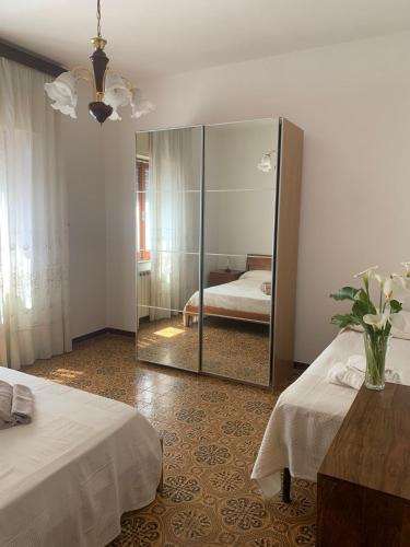 - une chambre avec 2 lits et un miroir dans l'établissement Ca' Fontanini, à Luni