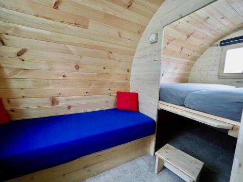 a room in a tiny house with a bed and a bench at Holzhütte J23 klein in Reichenau