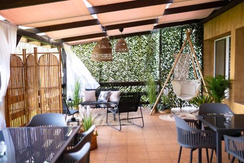 a patio with chairs and tables and a green hedge at Gościniec Paradise in Mierzęcice