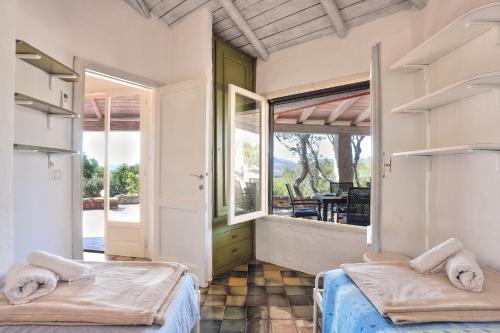 two beds in a room with a large window at Volpe by DomusAway in Monte Petrosu
