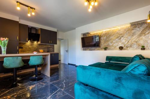 a living room with a blue couch and a kitchen at Luxury Hedone Apartment near the Bridge with Private SPA Zone in Zadar