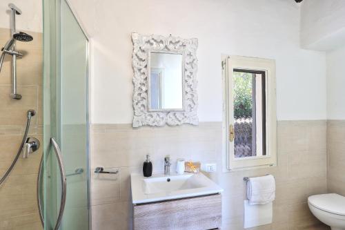 a bathroom with a sink and a toilet and a mirror at Volpe by DomusAway in Monte Petrosu