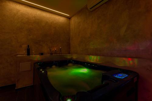ein Badezimmer mit einer Badewanne mit grünem Wasser in der Unterkunft Luxury Hedone Apartment near the Bridge with Private SPA Zone in Zadar