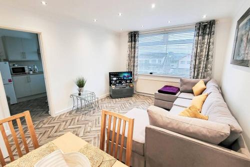 a living room with a couch and a table at Lovely & modern 2-Bedroom Flat above shop in Tonteg in Llantwit Fardre