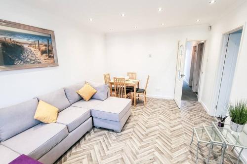 a living room with a couch and a table at Lovely & modern 2-Bedroom Flat above shop in Tonteg in Llantwit Fardre