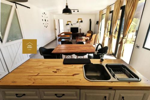 sala de estar con mesas y sillas y cocina en Piri Home Casa de Montaña en Los Molles