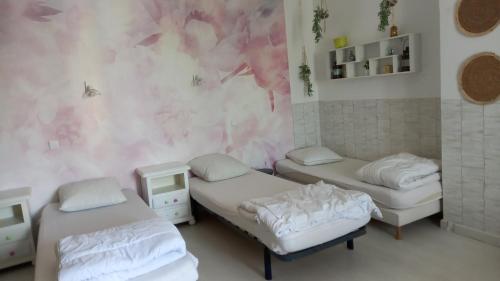 a room with three beds and a pink wall at Contre Vents et Marais in Vix