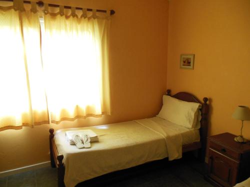 een slaapkamer met een bed en een raam met twee handdoeken erop bij Cabañas Valeria Kaupe in Valeria del Mar