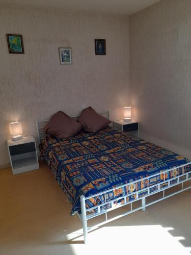 1 dormitorio con 1 cama con 2 mesas y 2 lámparas en Location Cure Thermale Barbotan Les Thermes, en Barbotan-les-Thermes
