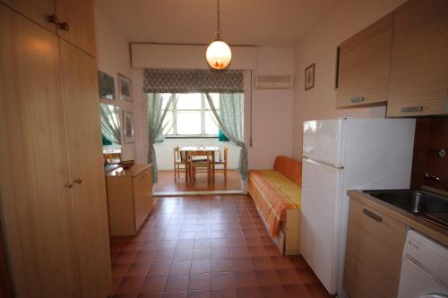 a kitchen with a couch and a refrigerator and a table at Agenzia Vear Mare 23 in Lido delle Nazioni