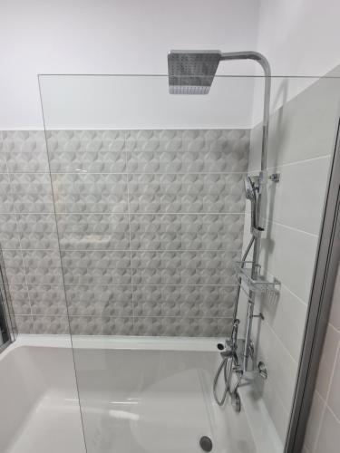 a shower with a glass door in a bathroom at Global Residence Lake View in Bucharest