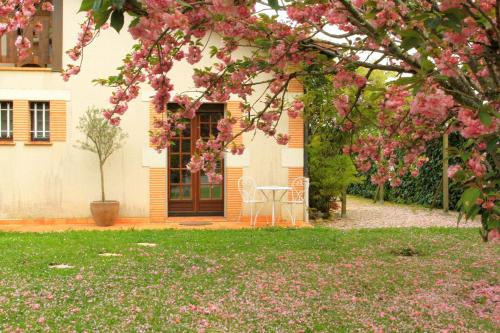 a house with pink flowers in the yard at le mas des cerisiers le temple sur lot in Le Temple-sur-Lot