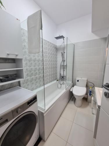 a bathroom with a washing machine and a toilet at Global Residence Lake View in Bucharest