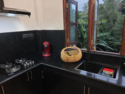 a black kitchen with a sink and a window at Villa Freiheit Himmel in Bentota