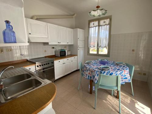 een keuken met een tafel met een tafelkleed erop bij Casa Enza: appartamento a un passo dal mare. in Bordighera