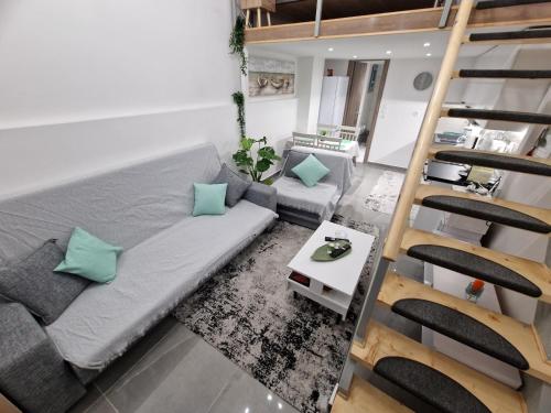uma sala de estar com um sofá e uma escada em Dimosthenis_Loft1 em Atenas