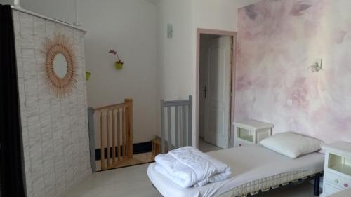 une chambre avec un lit et un miroir au mur dans l'établissement Contre Vents et Marais, à Vix