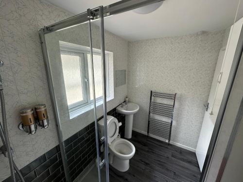 uma casa de banho com um WC e uma cabina de duche em vidro. em 116 Maison Dieu Road Room C in Dover em Dover