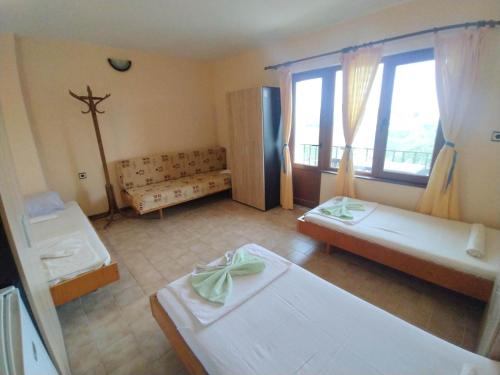 a room with two beds and a cross on the wall at Prostor Guest House in Byala