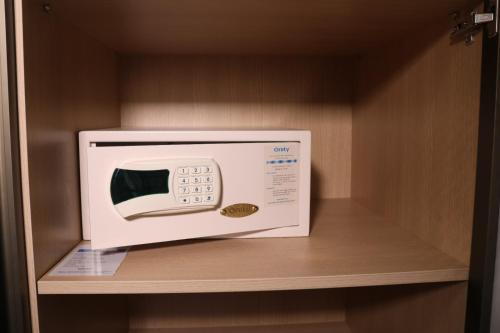 a microwave sitting on top of a shelf at Flat Premium Particular Cullinan Hotel in Brasilia