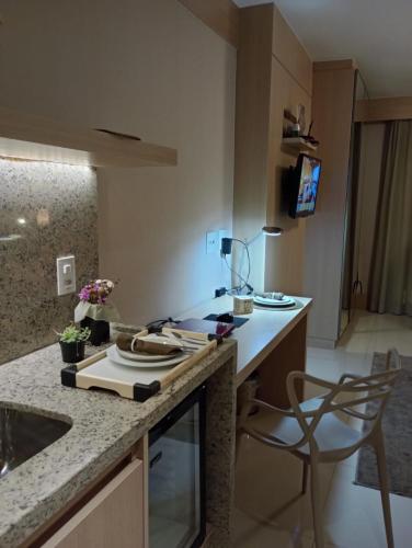 a kitchen with a counter with a sink and a chair at Flat Premium Particular Cullinan Hotel in Brasilia