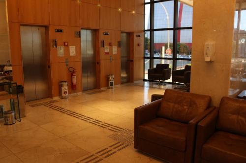a lobby with a couch and a fire hydrant in a building at Flat Premium Particular Cullinan Hotel in Brasilia