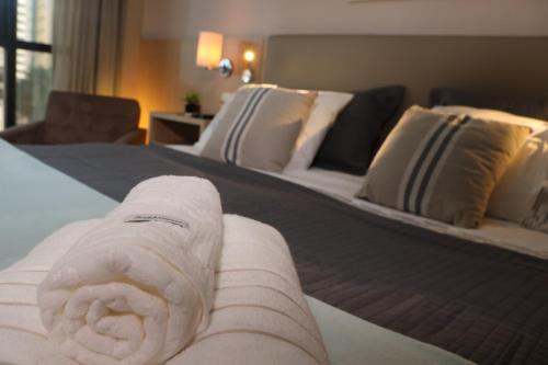 a white rolled up towel on a bed in a hotel room at Flat Premium Particular Cullinan Hotel in Brasilia