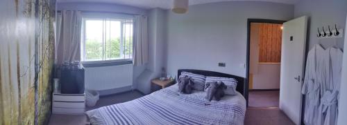 um quarto com uma cama e uma janela em Dan's House em Manchester