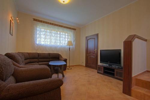 a living room with a couch and a flat screen tv at Przy Dębach in Stargard