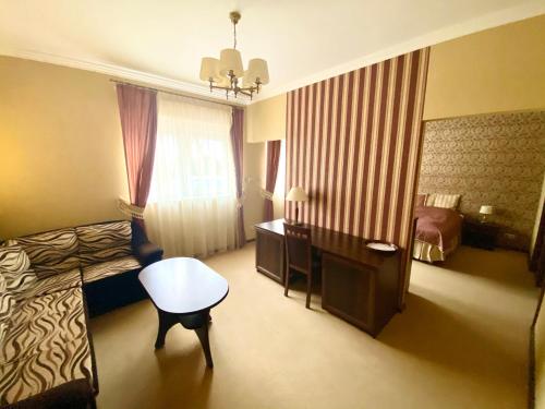 a hotel room with a bedroom with a bed and a desk at Przy Dębach in Stargard
