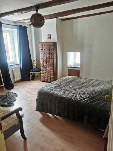 une chambre avec un lit et une chaise dedans dans l'établissement Maison de village brocante, à Coucouron