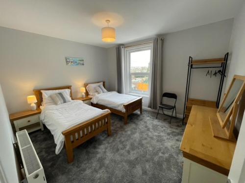 a bedroom with two beds and a window at Dog Friendly Town House in Paignton