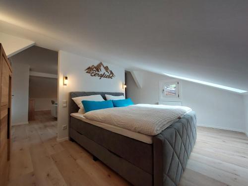 ein Schlafzimmer mit einem großen Bett mit blauen Kissen in der Unterkunft AlpenLodge Berchtesgaden in Berchtesgaden