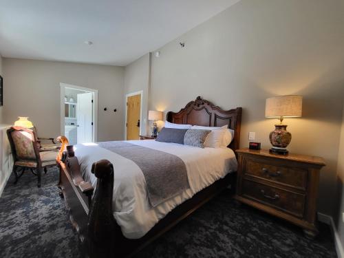 a bedroom with a large bed and a chair at The Stowe Village Inn in Stowe